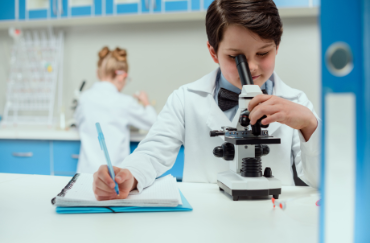 schoolboy-with-microscope-and-copybook-in-science-QUHLD8Q.png